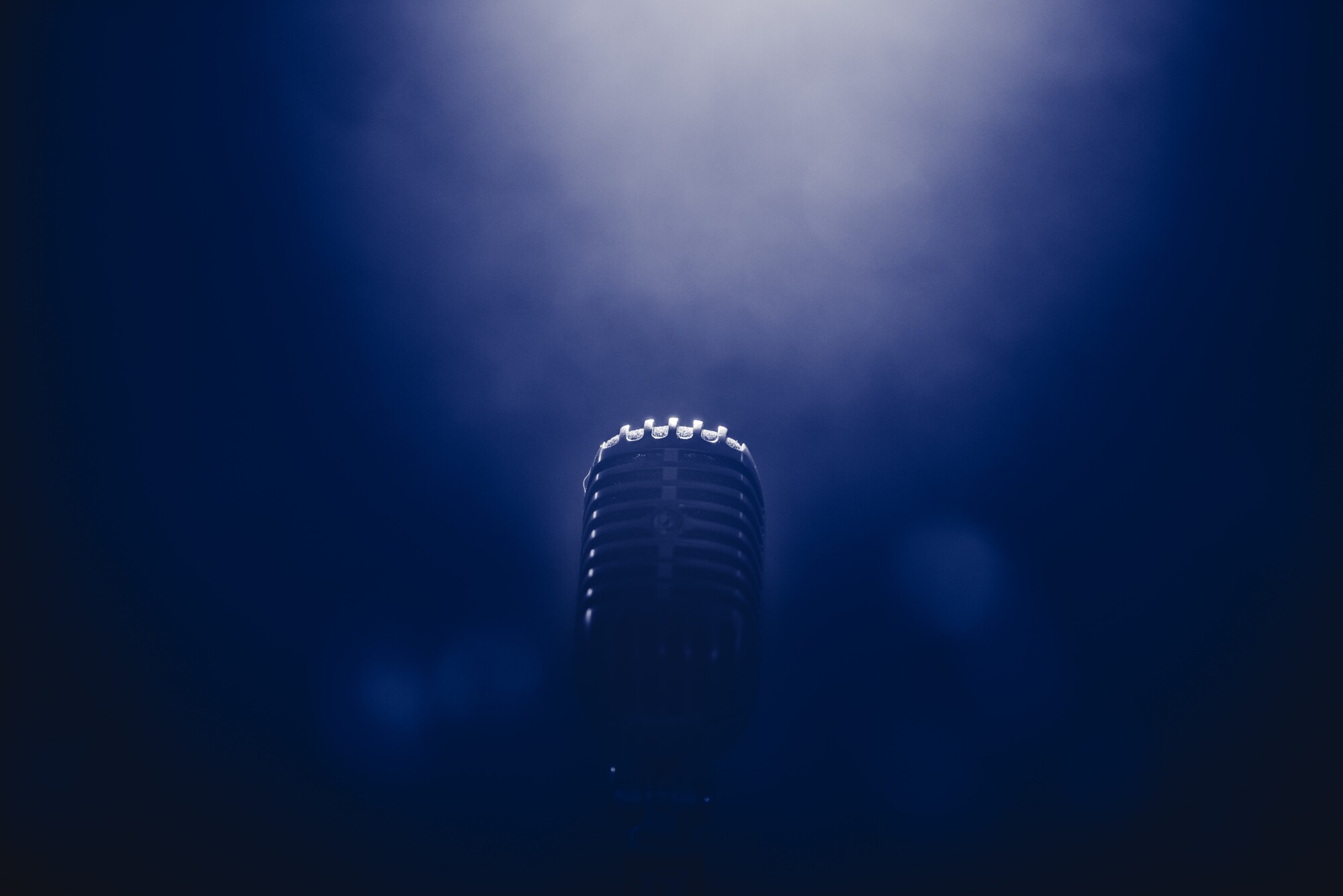 A silver microphone on a dark blue background