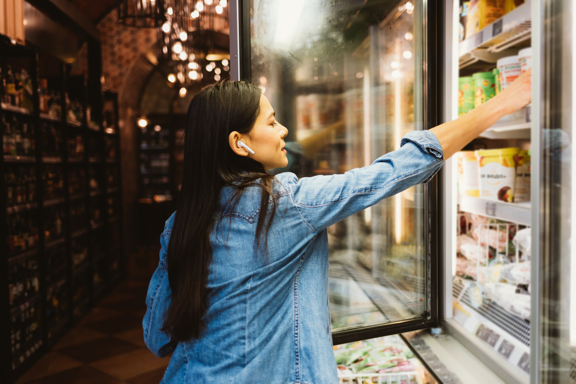 Woman takes ice cream out of a freezer